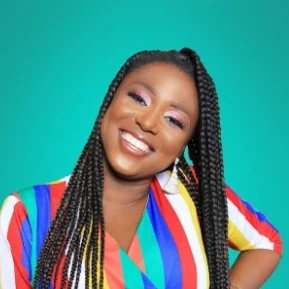 Smiling person in colorful striped shirt on teal background.