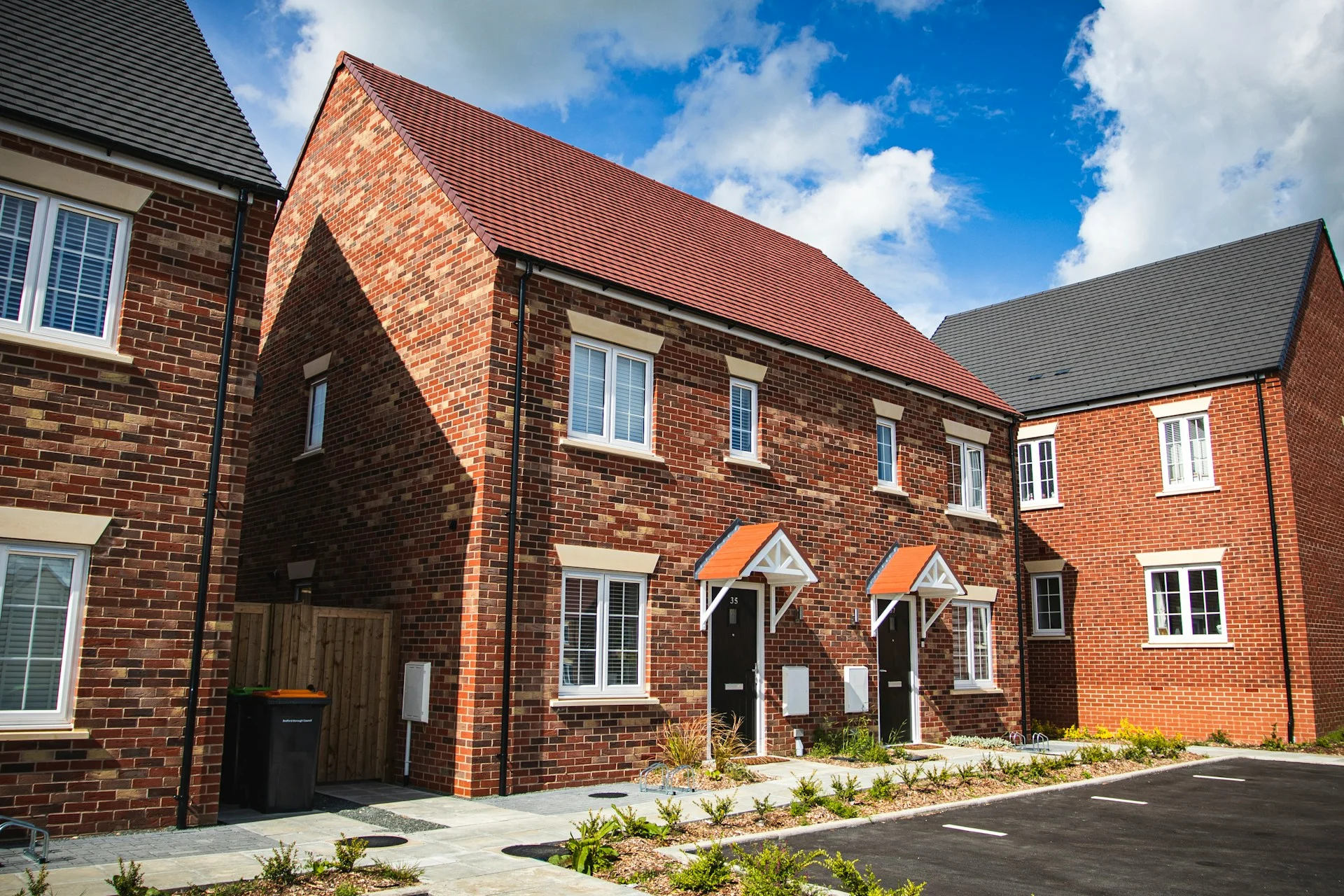 Modern brick townhouses with parking spaces.