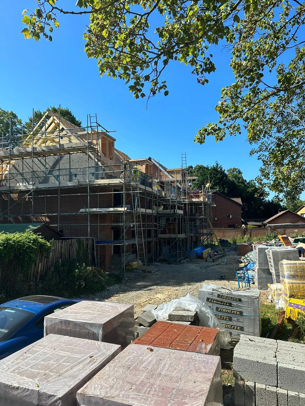 Construction site with house scaffolding and building materials.