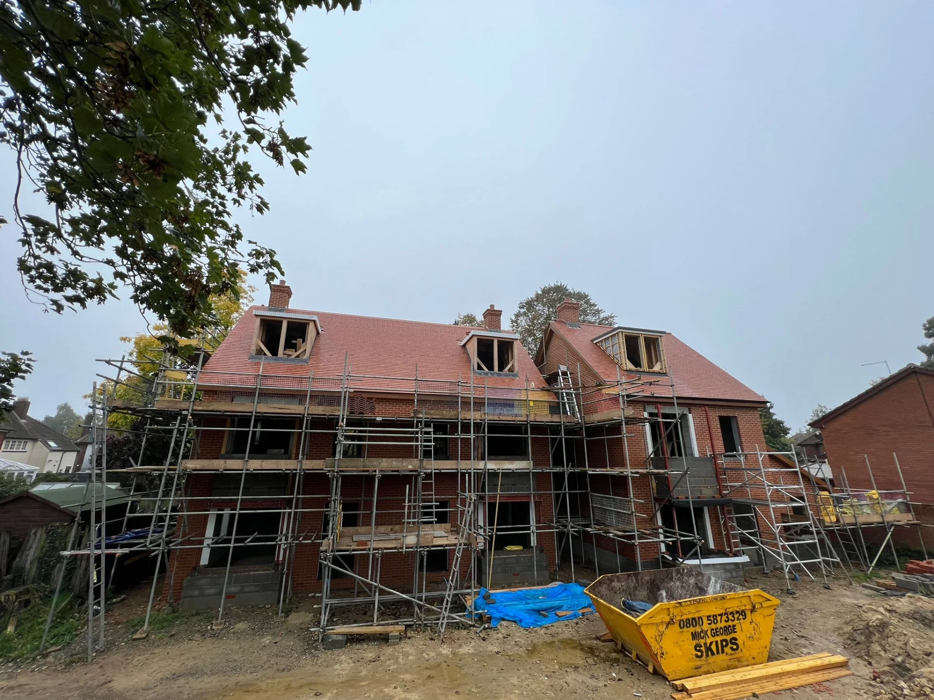 Two-story house under construction with scaffolding.